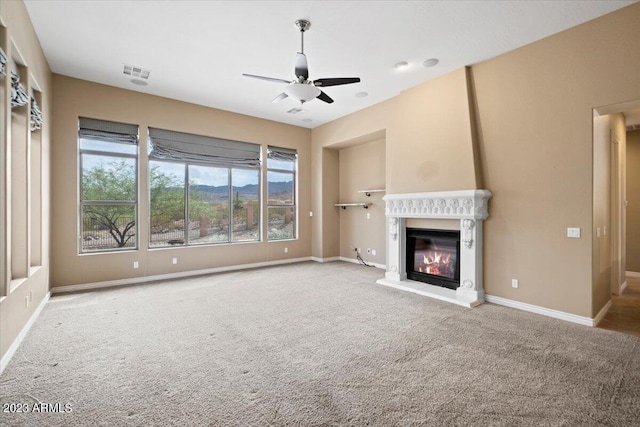 unfurnished living room featuring carpet and ceiling fan