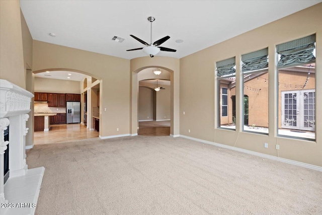 unfurnished living room with ceiling fan and light colored carpet