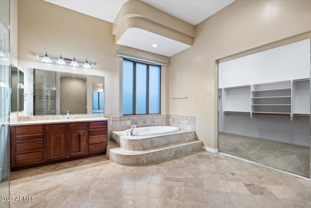 bathroom with a relaxing tiled tub and vanity