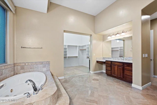 bathroom featuring vanity and tiled bath