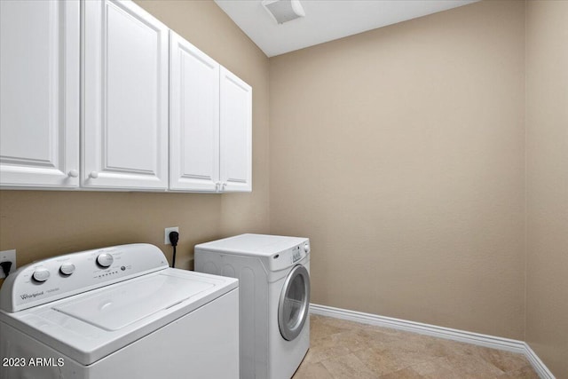 washroom featuring washing machine and dryer and cabinets