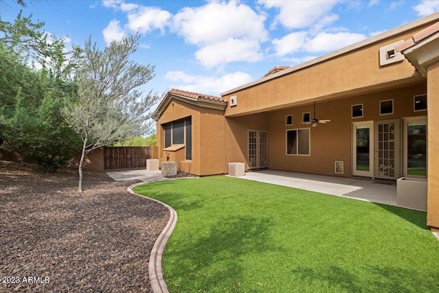 back of house with a patio area, ceiling fan, and a yard