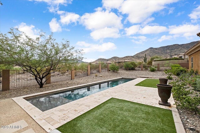 view of swimming pool with a lawn, a mountain view, and a patio