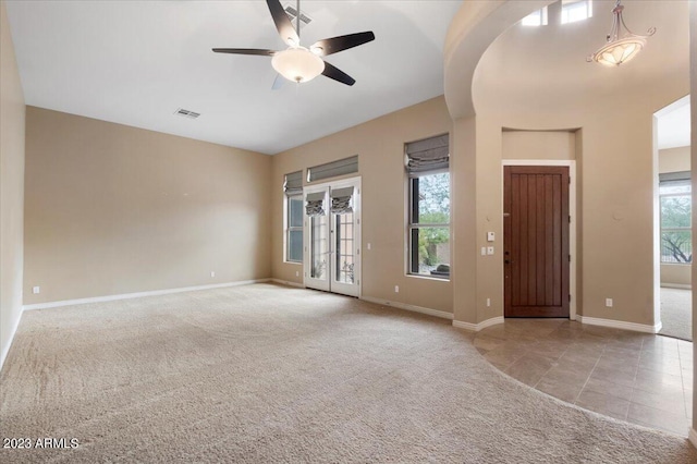 spare room featuring a wealth of natural light, ceiling fan, and light colored carpet