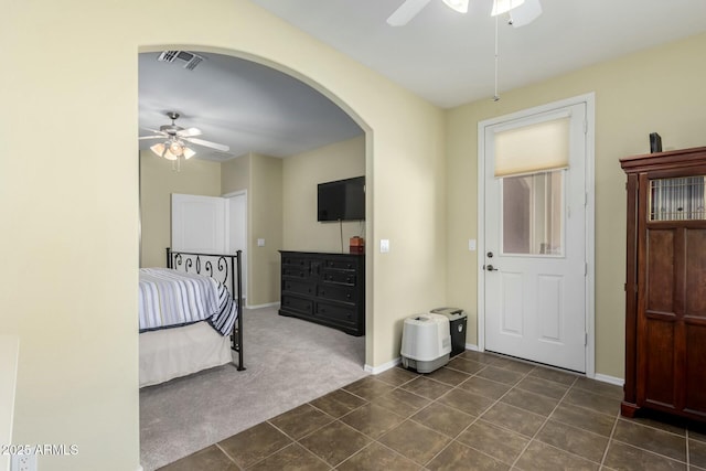 unfurnished bedroom with ceiling fan and dark colored carpet