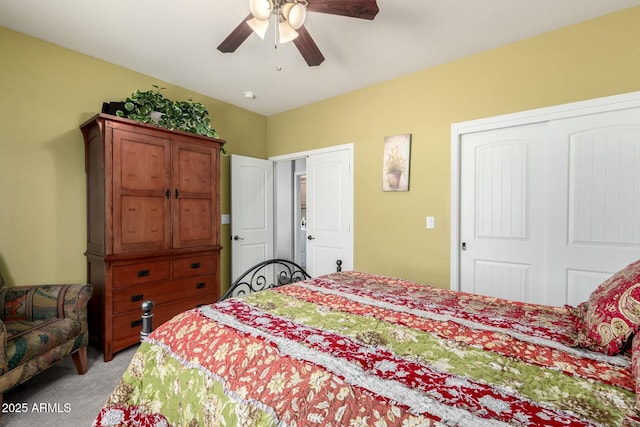 bedroom featuring multiple closets, light colored carpet, and ceiling fan