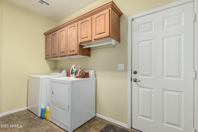 laundry room with cabinets, washing machine and clothes dryer, and dark tile patterned flooring