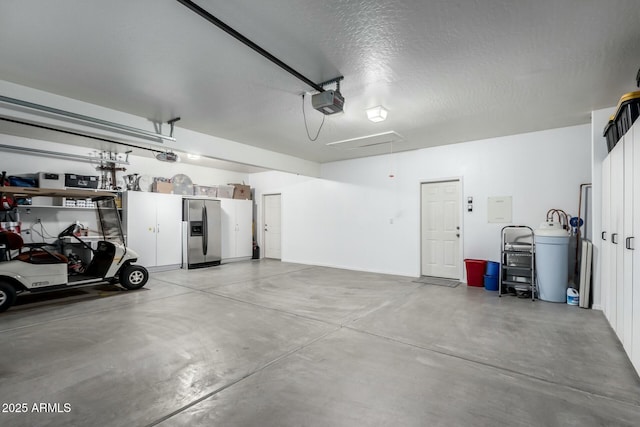 garage featuring a garage door opener and stainless steel fridge