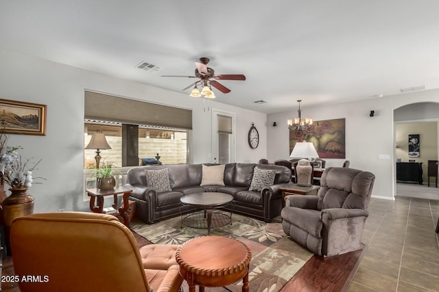 living room featuring tile patterned flooring and ceiling fan with notable chandelier