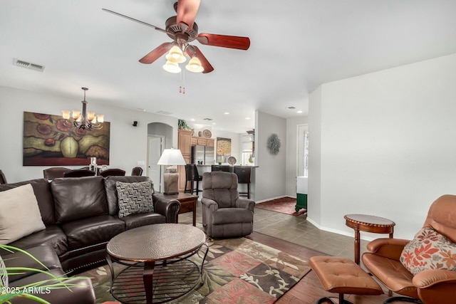 living room featuring tile patterned flooring and ceiling fan with notable chandelier