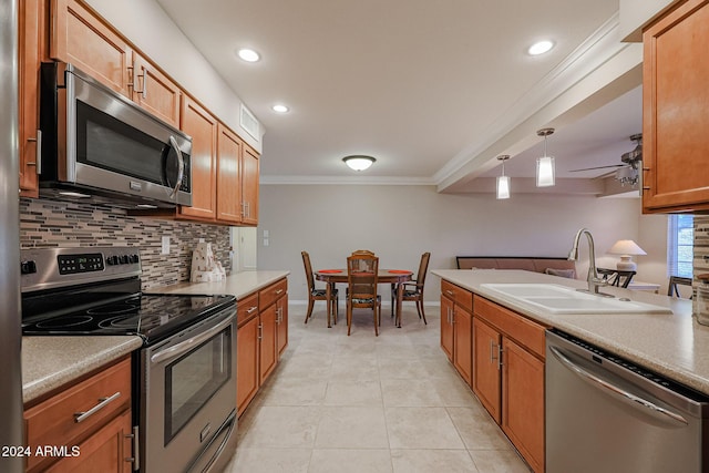 kitchen with ceiling fan, sink, stainless steel appliances, decorative light fixtures, and ornamental molding