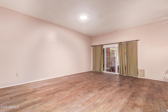 spare room featuring a textured ceiling and wood finished floors