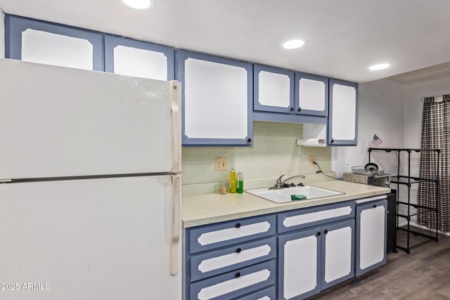 kitchen featuring dark wood-style floors, recessed lighting, light countertops, freestanding refrigerator, and a sink