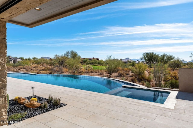 view of swimming pool featuring a patio, fence, and a pool with connected hot tub