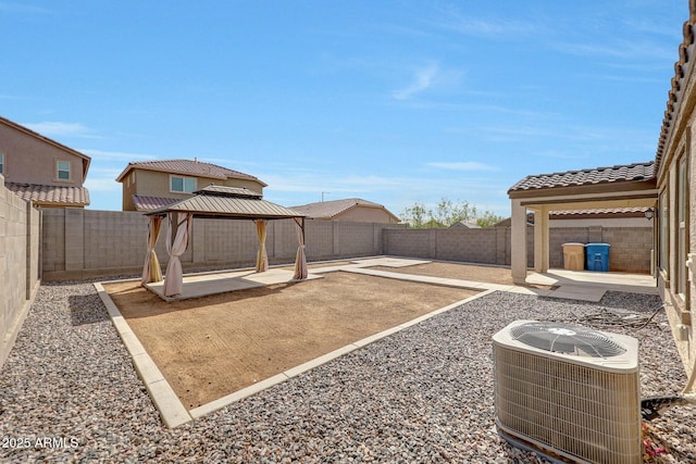 view of yard with a gazebo, a fenced backyard, central AC, and a patio