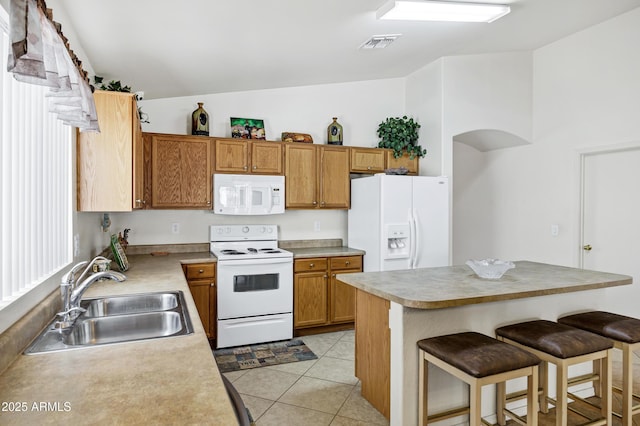 23862 W Chambers St, Buckeye, AZ 85326 - kitchen featuring white appliances, a sink, light countertops, and a breakfast bar area