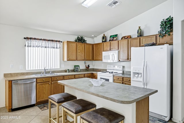 23862 W Chambers St, Buckeye, AZ 85326 - kitchen featuring white appliances, a sink, lofted ceiling, brown cabinetry, and a kitchen bar