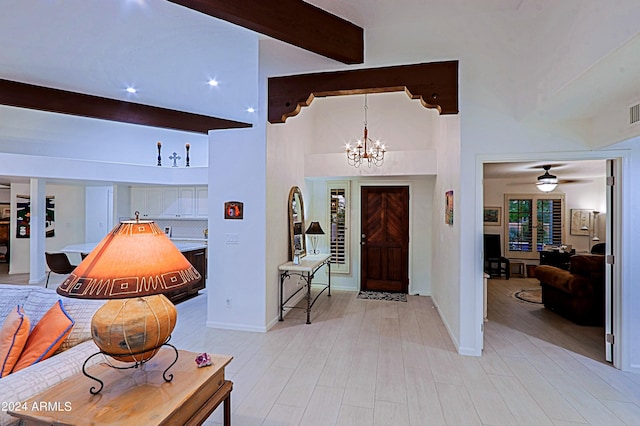 entrance foyer featuring beamed ceiling, ceiling fan with notable chandelier, light hardwood / wood-style floors, and a towering ceiling