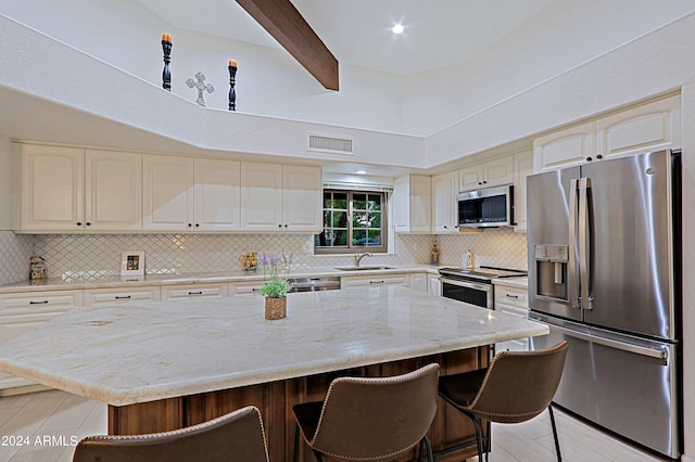 kitchen with stainless steel appliances, a breakfast bar area, a center island, and backsplash