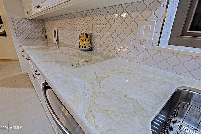 kitchen with tasteful backsplash, stainless steel dishwasher, sink, and cream cabinets