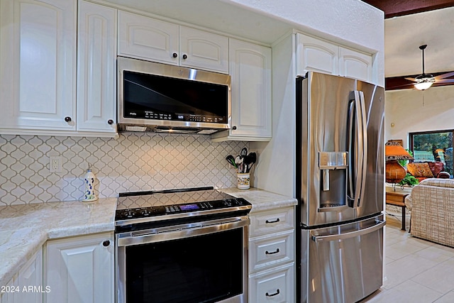 kitchen featuring stainless steel appliances, light stone counters, ceiling fan, light tile patterned floors, and decorative backsplash