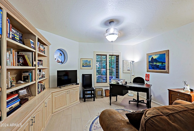 office area with a textured ceiling and ceiling fan