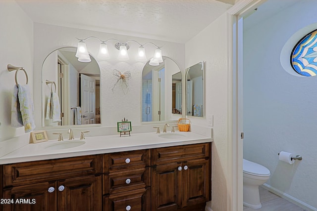 bathroom featuring vanity, a textured ceiling, and toilet