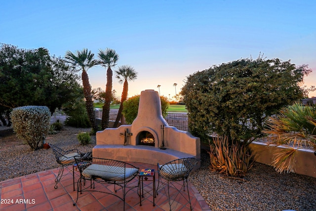 patio terrace at dusk with exterior fireplace