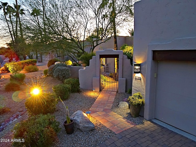 yard at dusk featuring a garage