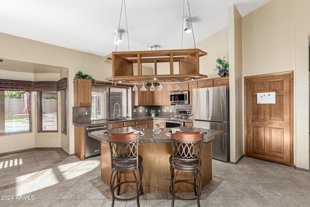 kitchen featuring sink, light tile patterned flooring, a center island, and appliances with stainless steel finishes