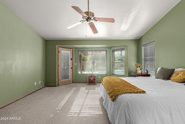 bedroom featuring vaulted ceiling, a textured ceiling, ceiling fan, and carpet