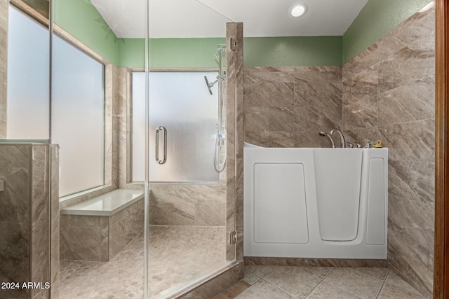 bathroom with a shower with door and tile patterned flooring