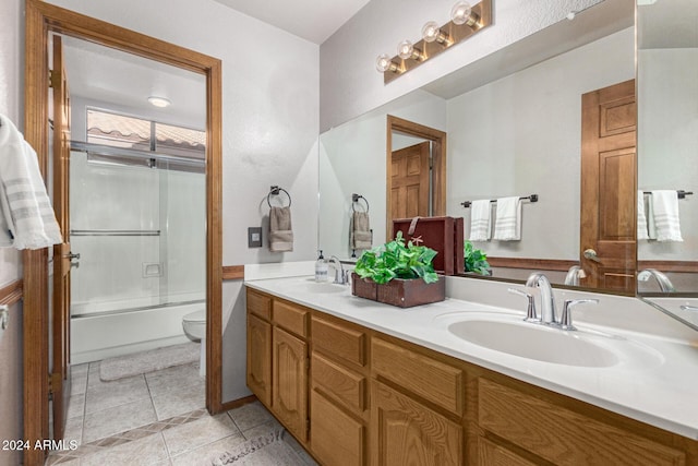 full bathroom with toilet, tile patterned flooring, enclosed tub / shower combo, and vanity