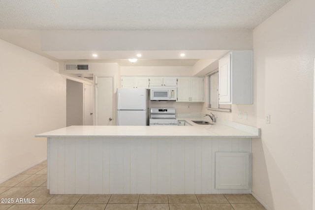 kitchen featuring light countertops, white appliances, a sink, and white cabinets