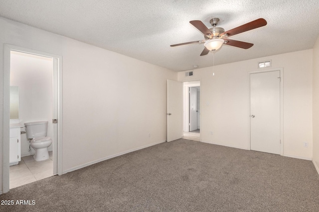 unfurnished bedroom with light carpet, a textured ceiling, visible vents, and ensuite bathroom