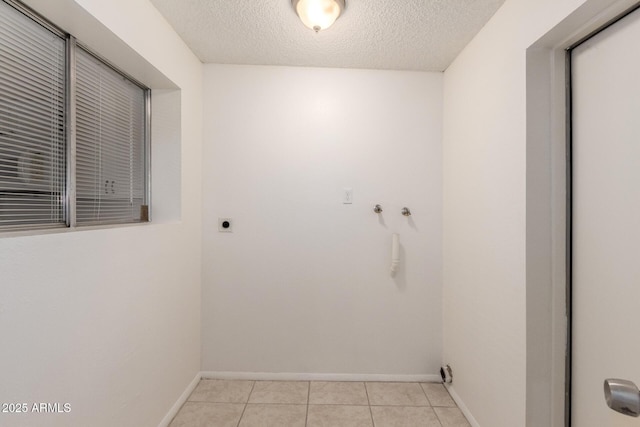 washroom with light tile patterned floors, a textured ceiling, laundry area, baseboards, and electric dryer hookup