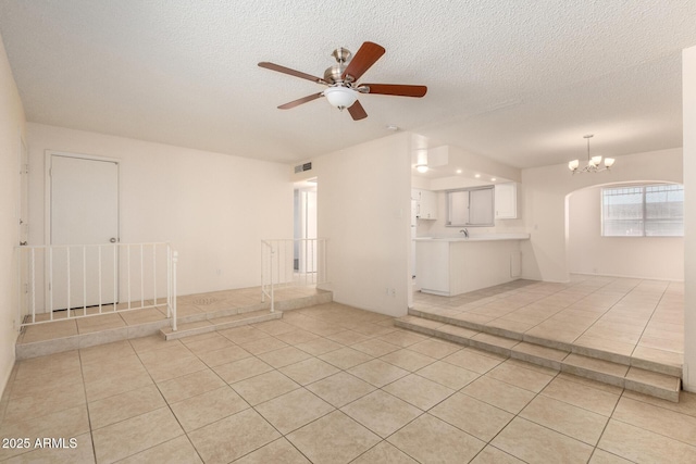 unfurnished room with light tile patterned floors, visible vents, and a textured ceiling