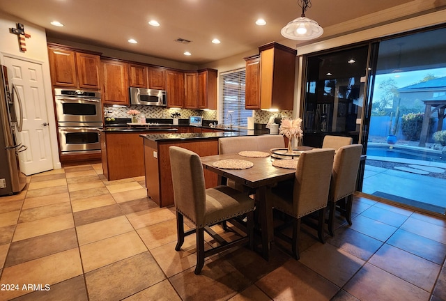 kitchen featuring pendant lighting, tasteful backsplash, recessed lighting, appliances with stainless steel finishes, and a kitchen island