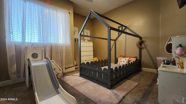 bedroom with dark carpet and baseboards