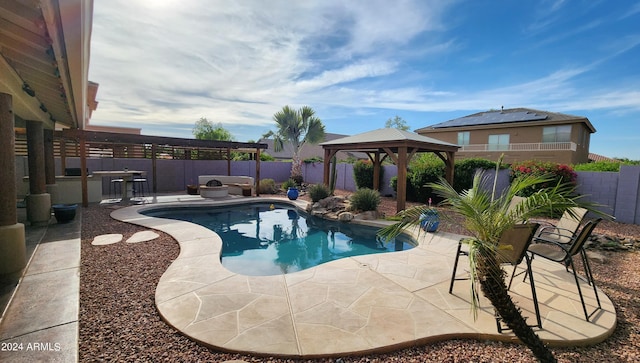 view of swimming pool with a patio area, a fenced backyard, a fenced in pool, and a gazebo