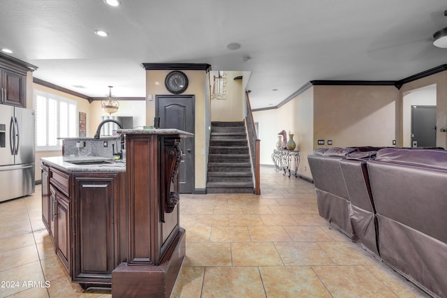 kitchen with dark brown cabinetry, an island with sink, stainless steel refrigerator with ice dispenser, and ornamental molding