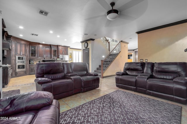 tiled living room with crown molding and ceiling fan