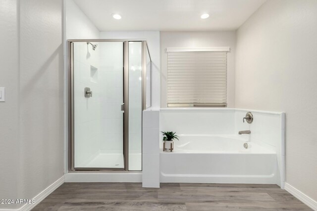 bathroom with hardwood / wood-style flooring and separate shower and tub