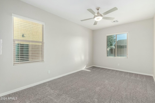 empty room featuring ceiling fan and carpet