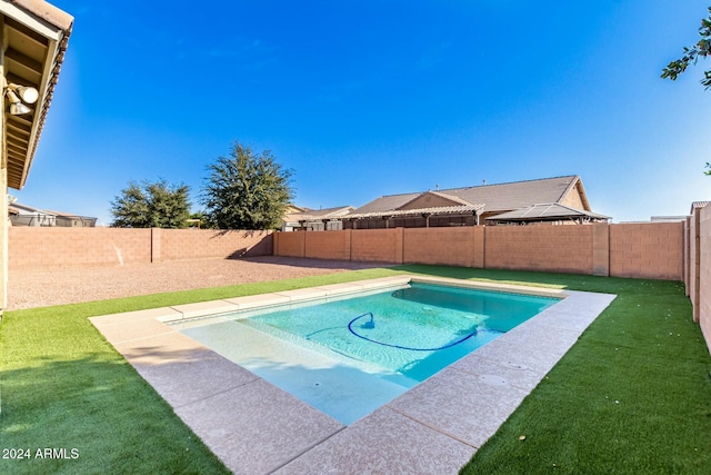 view of swimming pool featuring a yard