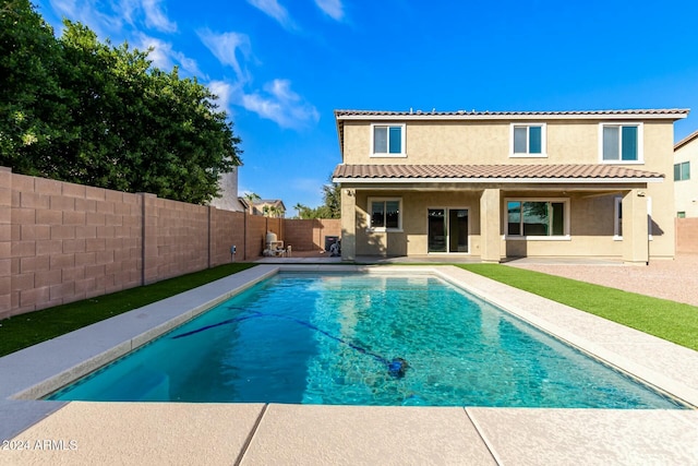 back of property featuring a fenced in pool and a patio