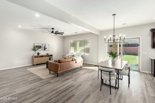 dining room featuring beamed ceiling, ceiling fan with notable chandelier, and light wood-type flooring