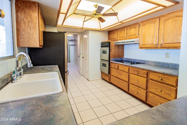 kitchen with ceiling fan, sink, stainless steel double oven, black electric stovetop, and light tile patterned floors