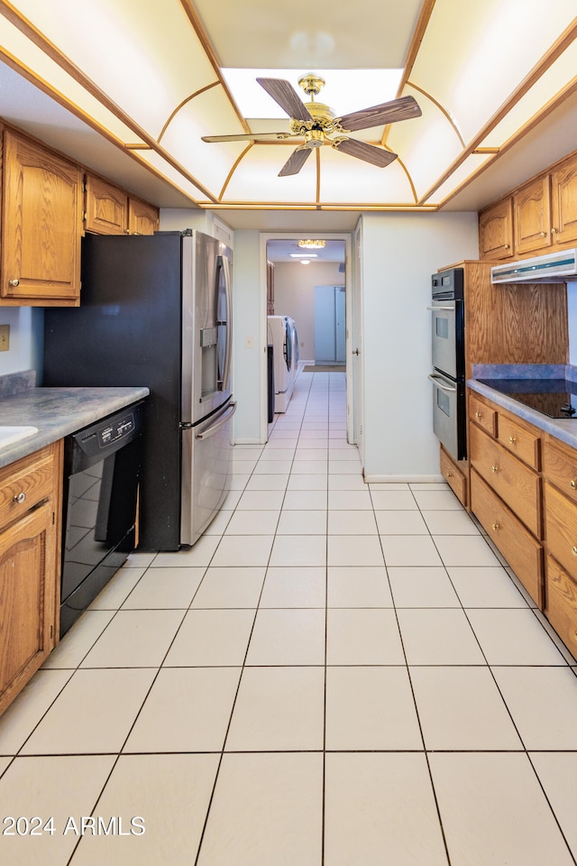 kitchen featuring black appliances, ceiling fan, independent washer and dryer, and light tile patterned floors