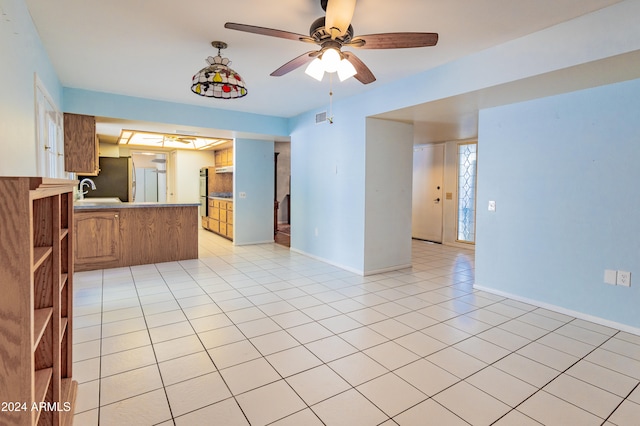 interior space with ceiling fan, light tile patterned floors, and sink